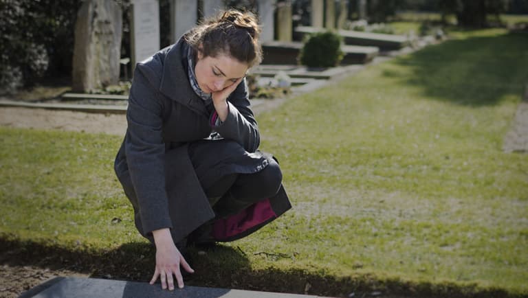 Woman mourning in Jewish cemetery